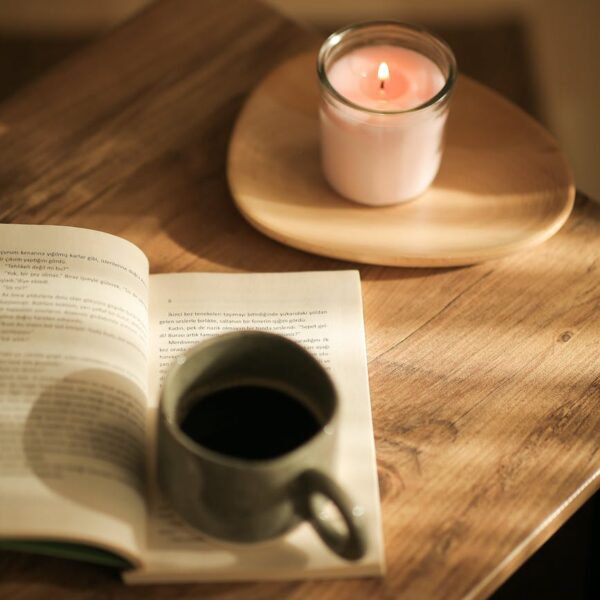 cup of coffee on a book and a candle