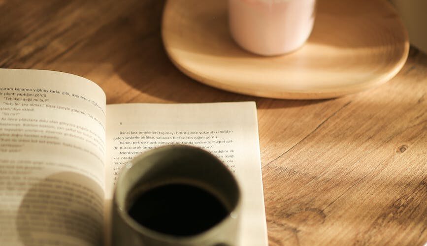 cup of coffee on a book and a candle