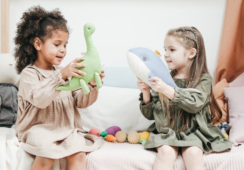 photo of two girls playing with stuffed animals