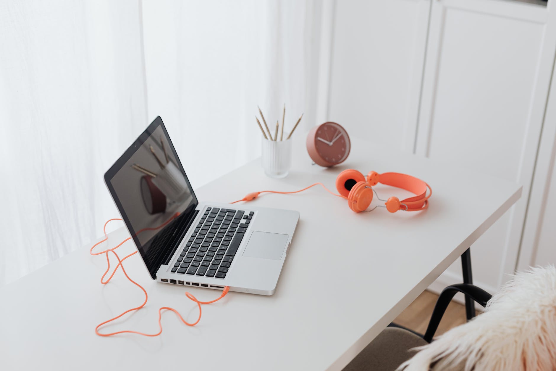 laptop and orange headphones on a desk