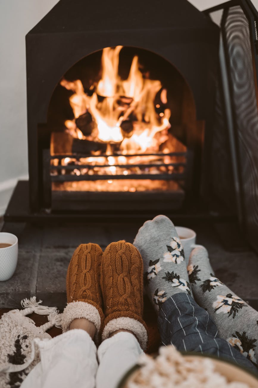 person wearing gray and white socks near brown fireplace