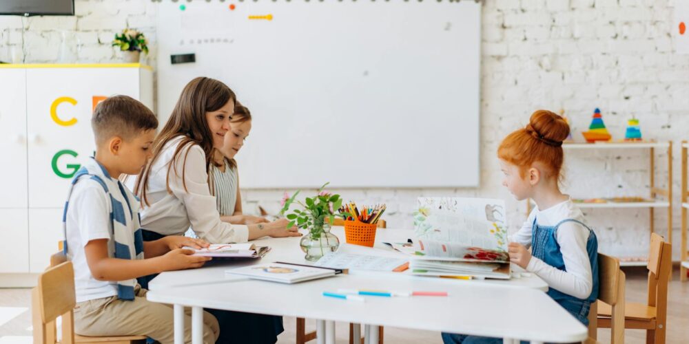 a teacher sitting with her students