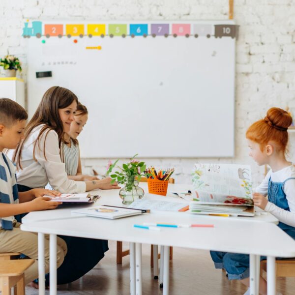 a teacher sitting with her students